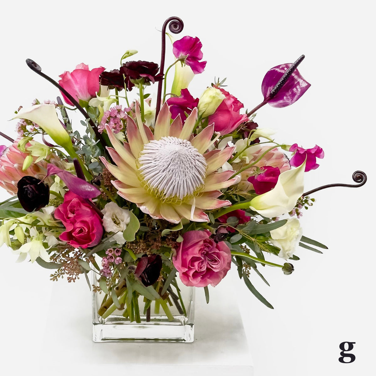 Large Low Flower Design from Artichokes and Pomegranates with Tropicals in Pinks, Whites and Purples
